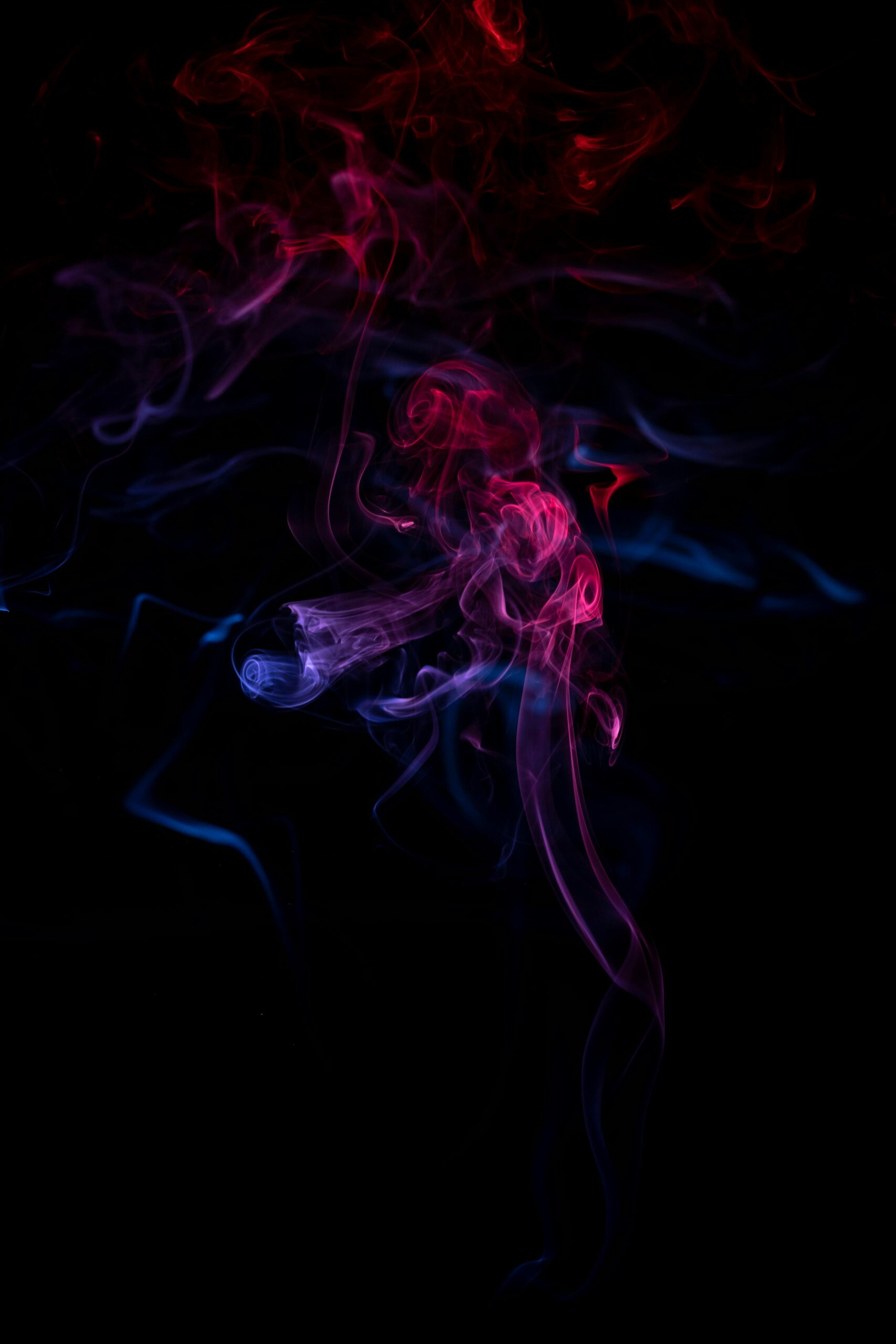 Creative smoke art with vibrant pink and purple hues against a dark background.